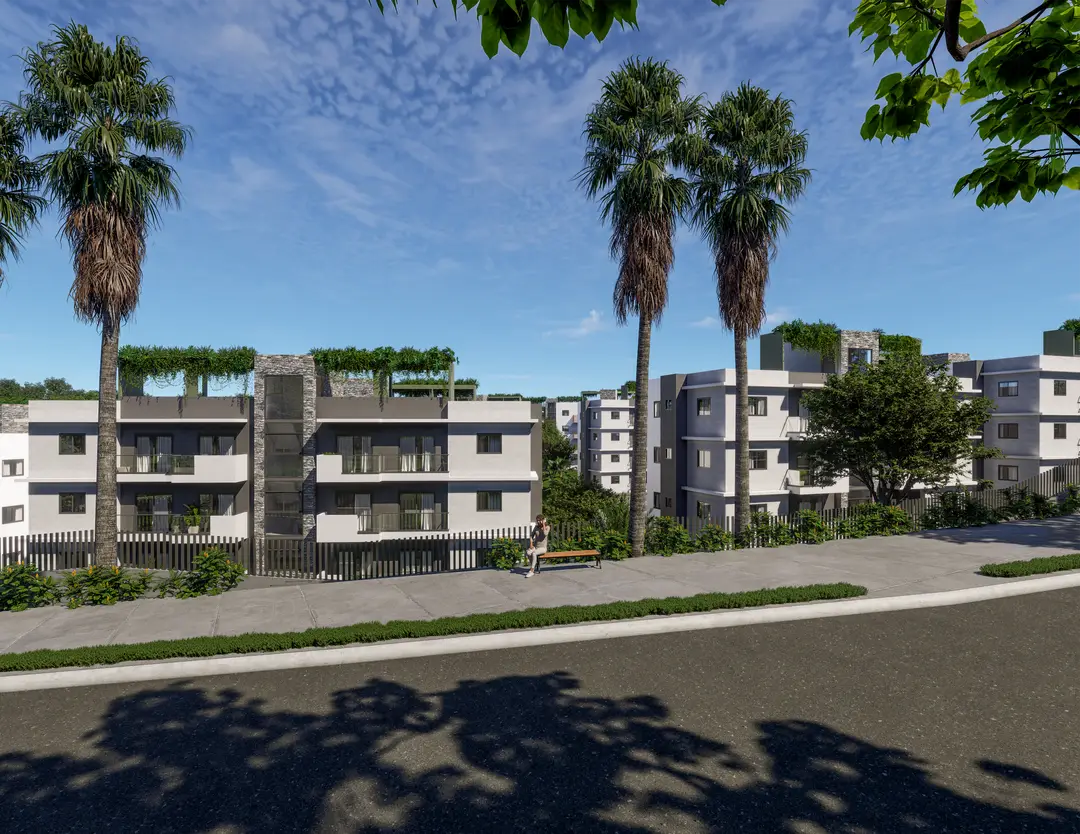 Conjunto residencial de Embassy Gardens con palmeras, terrazas verdes y banca frente a la calle